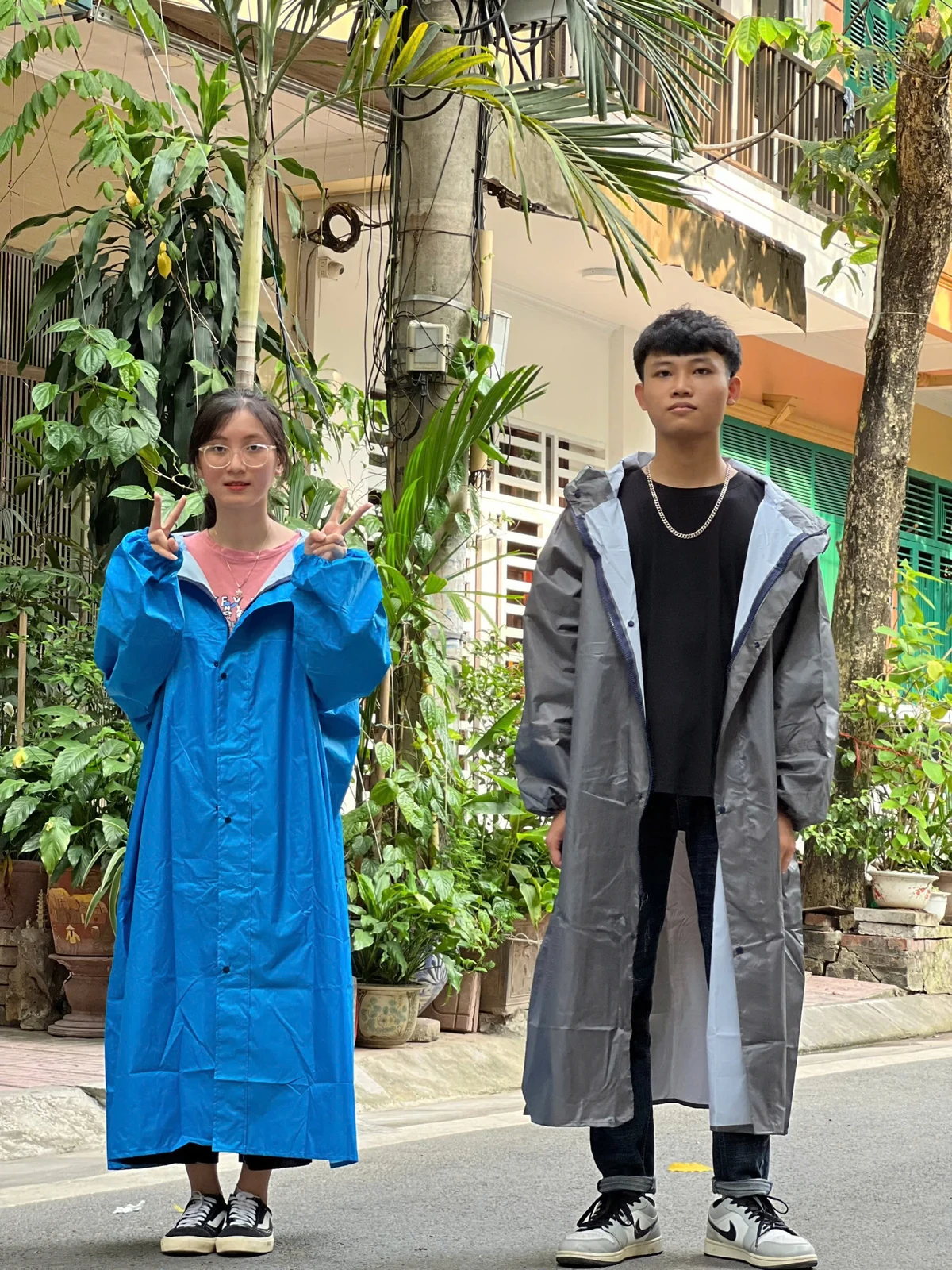 Ảnh thật dáng áo mưa măng tô Ảnh tư liệu hai người mặc áo mưa măng tô, người bên phải mặc màu xám mở vạt trước
