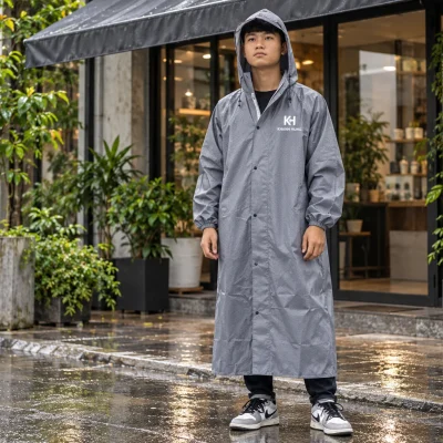 Minh họa người mặc áo mưa măng tô xám in nhận diện KH KHANH HUNG màu trắng trên ngực