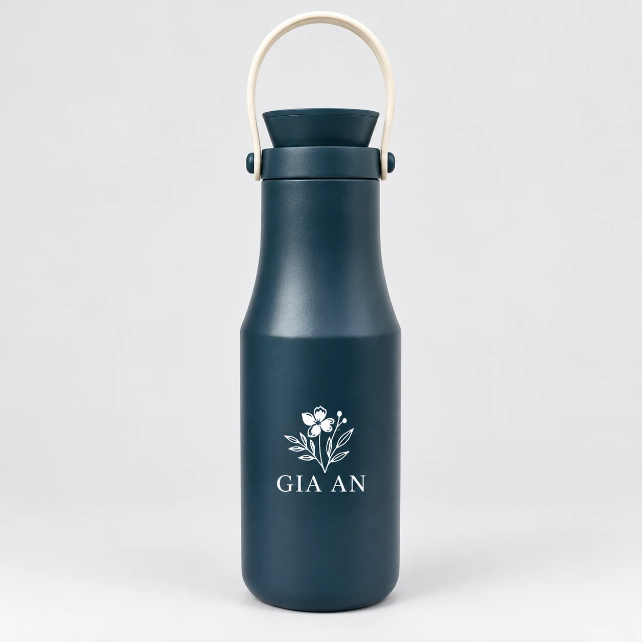 Mô phỏng nhận diện GIA AN màu trắng ở phần thân rộng của bình xanh 480 ml Mô phỏng biểu tượng hoa và tên GIA AN sáng màu trên bình xanh đậm 480 ml
