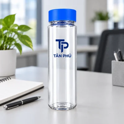 Minh họa bình 500 ml nắp xanh với logo TÂN PHÚ cạnh sổ và bút