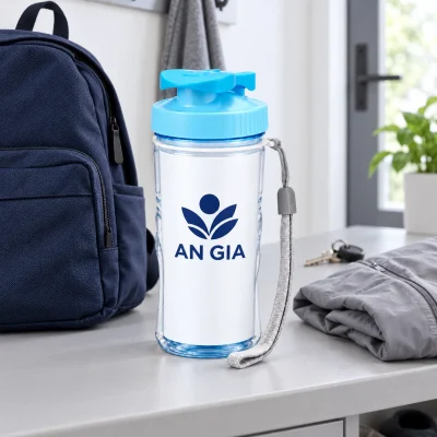 Minh họa bình Duy Tân 350 ml với tem AN GIA cạnh balo, áo và chìa khóa