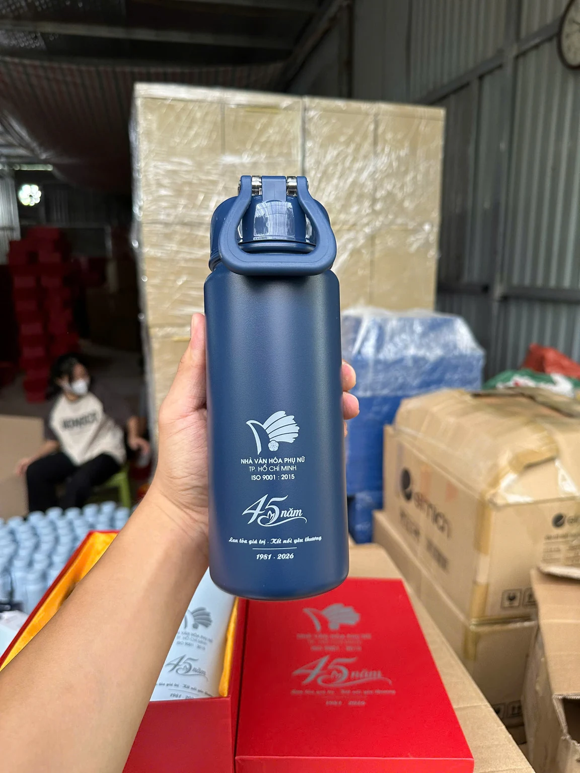 Bình xanh có quai ở nắp và phần in sáng được cầm trong tay