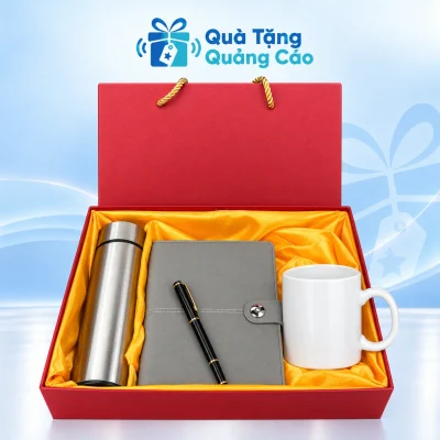 Minh họa đủ bộ BGS20 gồm bình bạc bên trái, sổ xám ở giữa, cốc trắng bên phải và bút đen trên sổ trong hộp đỏ