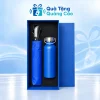 Minh họa đủ bộ trong hộp xanh khay đen: dù xanh bên trái với cán đen bạc, bình quai xách xanh bên phải