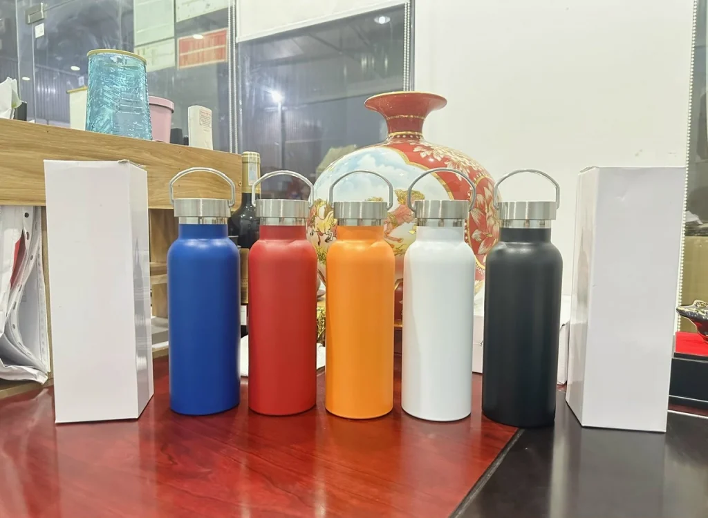 Tư liệu năm bình quai xách màu xanh, đỏ, cam, trắng và đen; bình xanh nằm bên trái