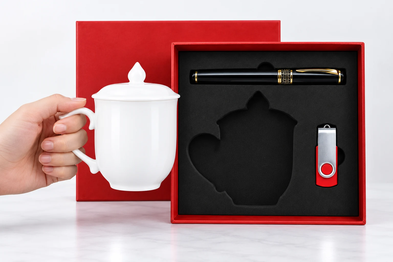 Minh họa cầm quai lấy cốc lửa khỏi hộp Minh họa một tay cầm quai cốc trắng ngoài hộp, ngăn cốc đã trống và bút cùng USB vẫn trong khay đen