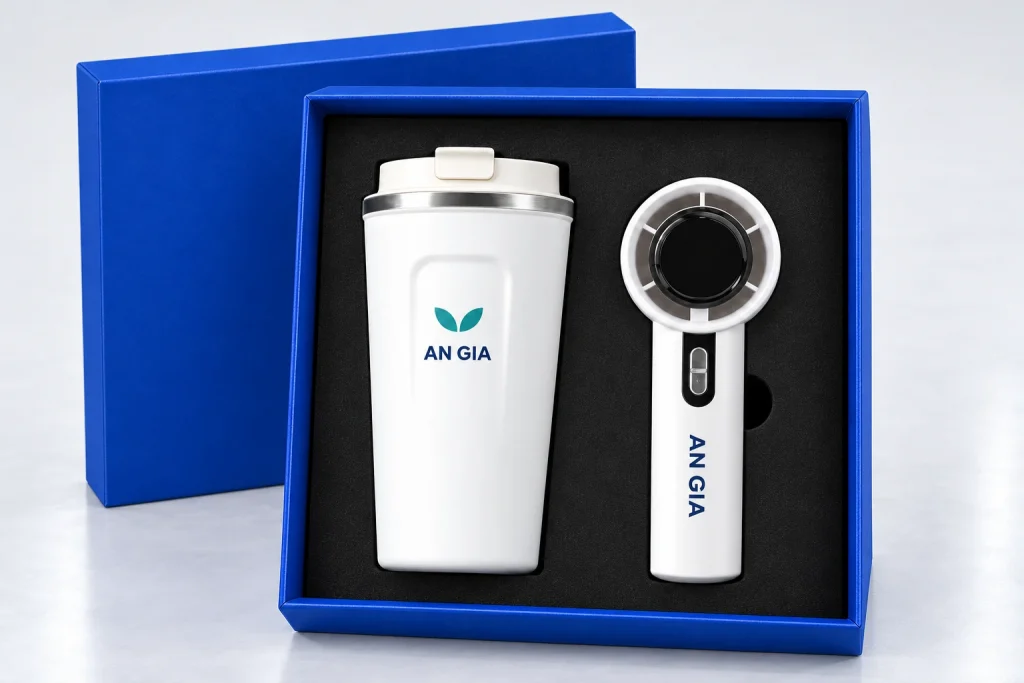 Minh họa logo lá AN GIA trên ly trắng và chữ AN GIA một màu ở tay cầm quạt
