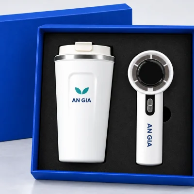 Minh họa logo lá AN GIA trên ly trắng và chữ AN GIA một màu ở tay cầm quạt