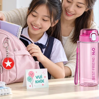 Minh họa bình Duy Tân hồng đặt trên bàn và móc khóa tròn gắn vào ba lô khi chuẩn bị đồ dùng