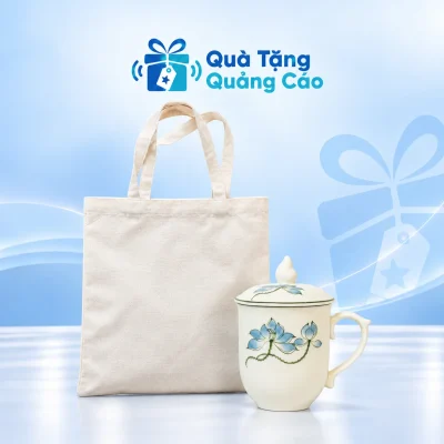 Minh họa cốc men kem sen xanh có nắp cạnh túi canvas mộc trên nền xanh nhạt