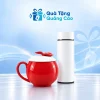 Minh họa cốc táo men đỏ có nắp trắng núm lá đỏ và bình giữ nhiệt trắng trên nền xanh nhạt