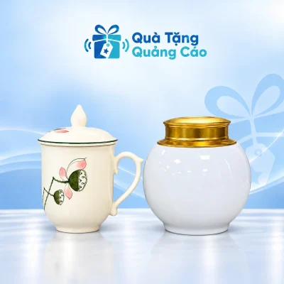 Minh họa hũ trà men trắng nắp đồng vàng và cốc sen men kem có nắp trên nền xanh nhạt