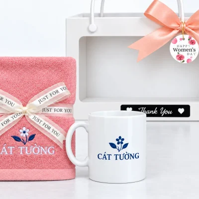 Minh họa nhận diện CÁT TƯỜNG thêu trên khăn hồng và in trên cốc trắng