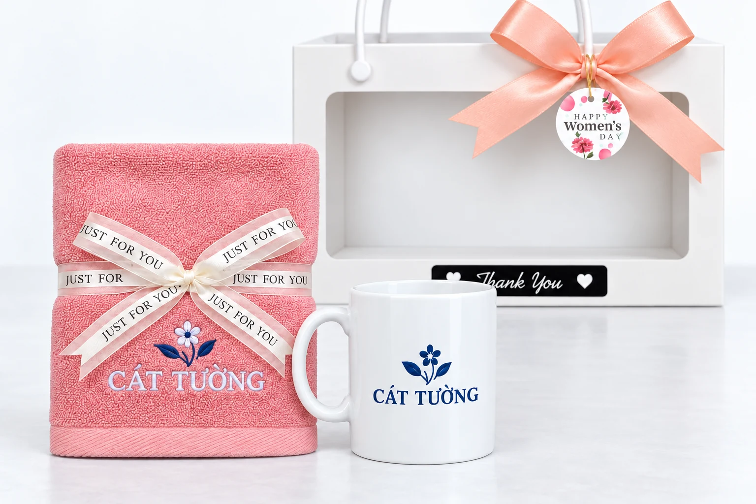 Minh họa thêu khăn và in một mặt cốc theo nhận diện Minh họa nhận diện CÁT TƯỜNG thêu trên khăn hồng và in trên cốc trắng