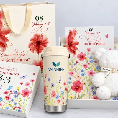 Minh họa nhận diện AN NHIÊN trên ly giữ nhiệt, cạnh hộp còn khăn gấu và thiệp