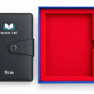 Minh họa sổ đen in UV MINH TRÍ đặt cạnh hộp, bút đen in một màu trắng nằm trong khay