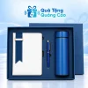 Minh họa sổ trắng phối dải xanh, bút xanh và bình xanh nắp trơn nằm trong khay hộp xanh trên nền thương hiệu