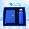 Minh họa đủ ba món: sổ xanh tai gài chữ C bên trái, bút xanh giữa và bình quai xách bên phải trong hộp xanh