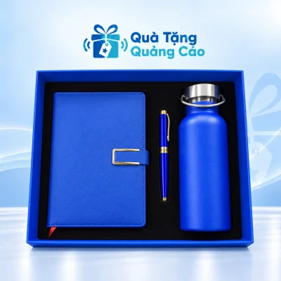Minh họa đủ ba món: sổ xanh tai gài chữ C bên trái, bút xanh giữa và bình quai xách bên phải trong hộp xanh