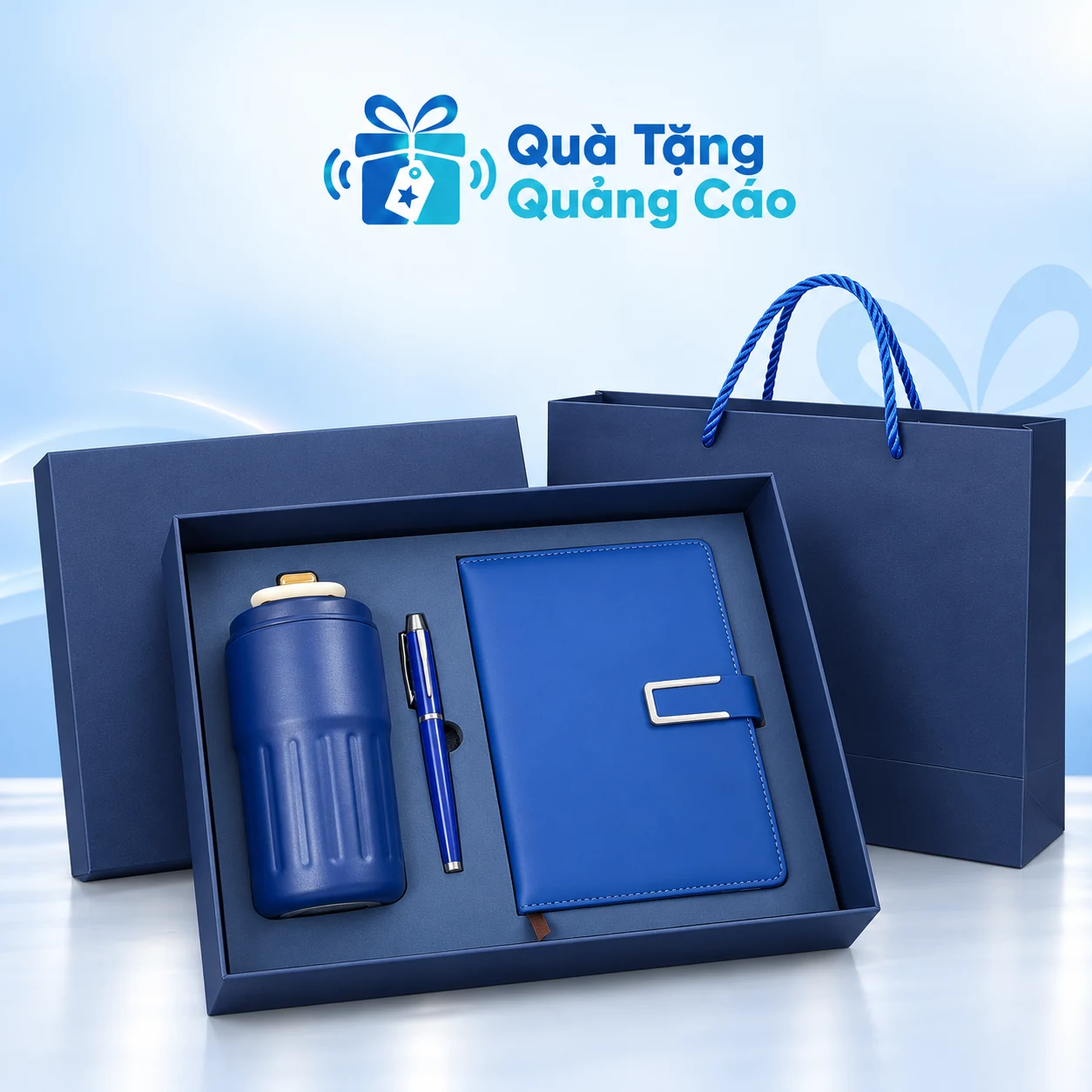 Minh họa bộ sổ chữ C, bình rãnh dọc và bút trong hộp Minh họa cả bộ sổ xanh tai gài chữ C, bình xanh rãnh dọc và bút xanh nằm trong khay hộp, túi giấy xanh phía sau