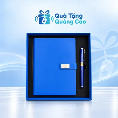 Minh họa sổ xanh trơn tai gài mặt chữ nhật và bút xanh phối vàng trong hộp viền xanh khay đen trên nền thương hiệu