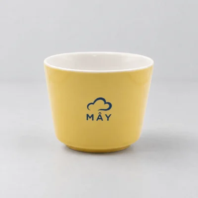 Mô phỏng logo MÂY xanh đậm trên cốc sứ Khánh An màu vàng