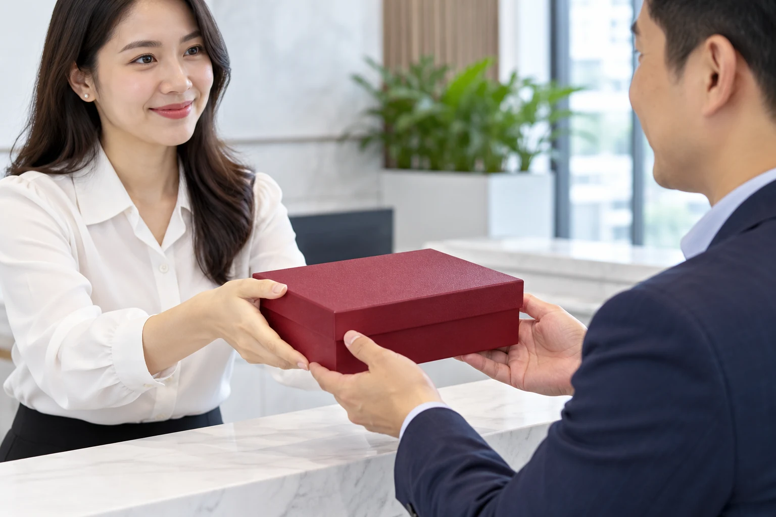 Minh họa trao hộp quà nắp gập Minh họa trao hộp quà đỏ rượu bằng hai tay tại bàn tiếp khách