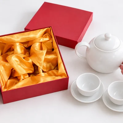 Minh họa xem lòng hộp lót vàng cùng bộ trà trắng đặt bên cạnh