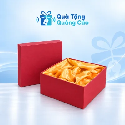 Hộp quà vuông đỏ với nắp rời và lớp lót vàng trên nền Quà Tặng Quảng Cáo