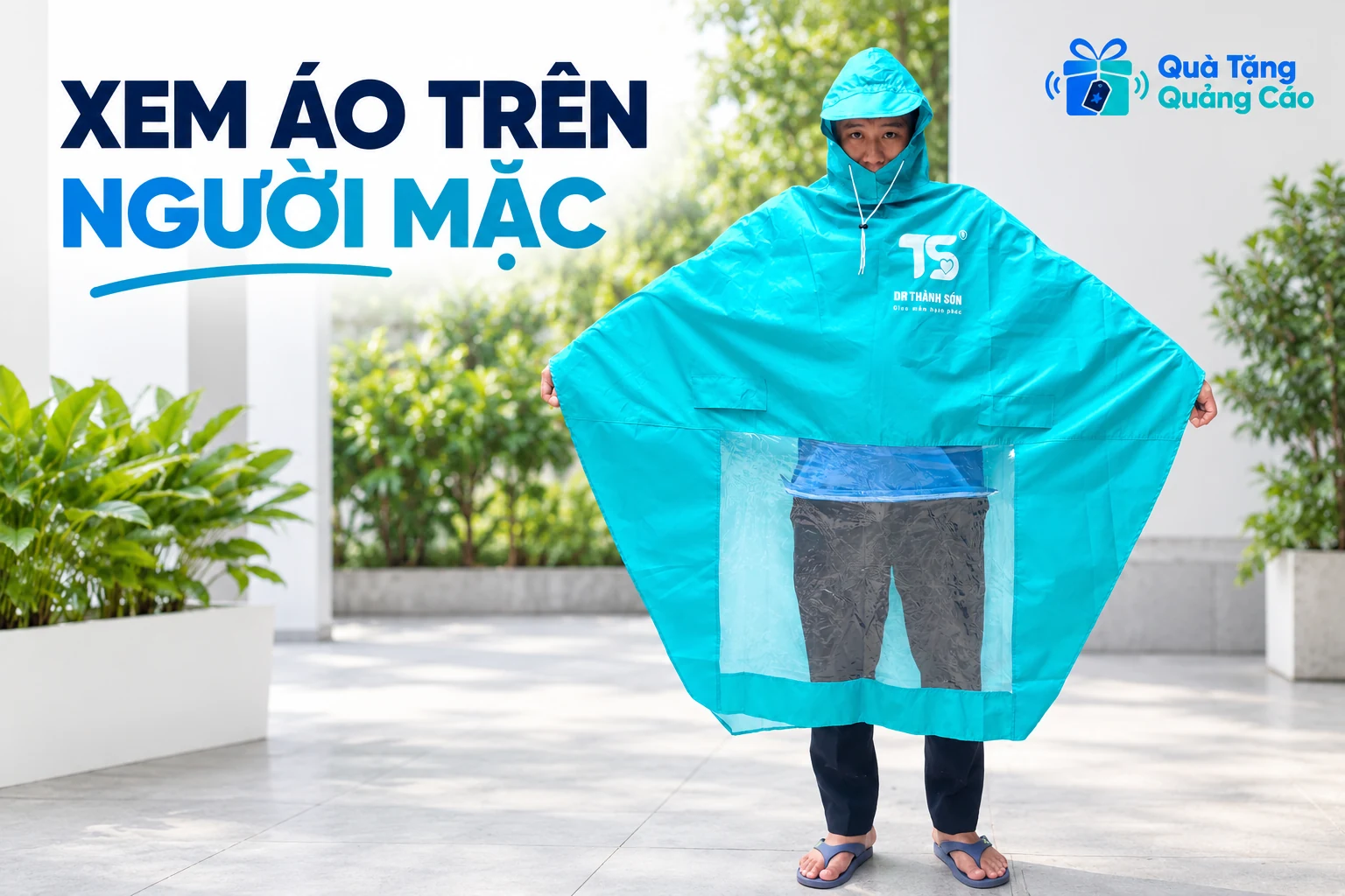 Người mặc thử áo mưa dáng choàng màu xanh, mở rộng hai mép như ảnh mẫu