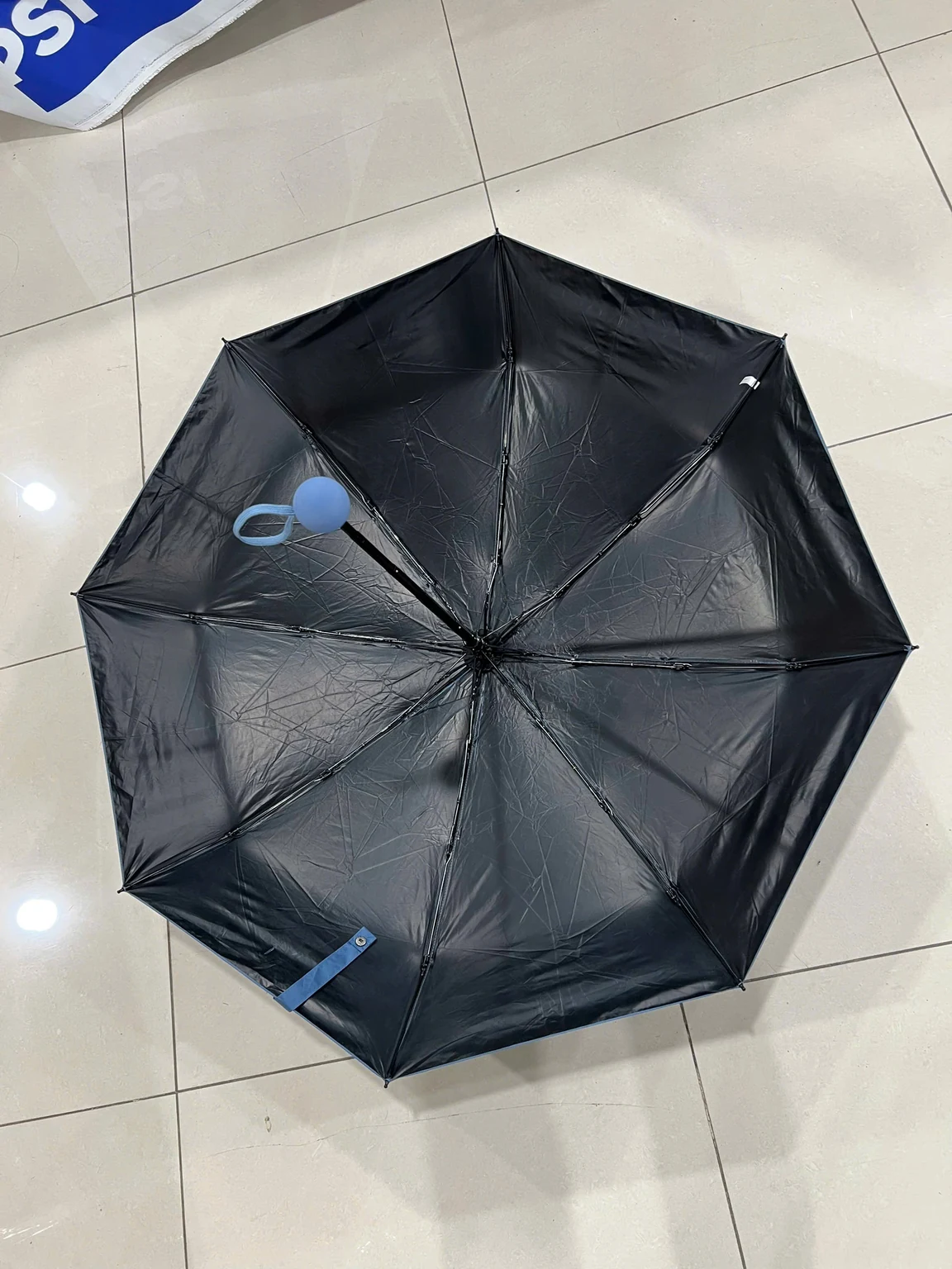 Phía dưới tán ô đen với khung, trục và dây giữ