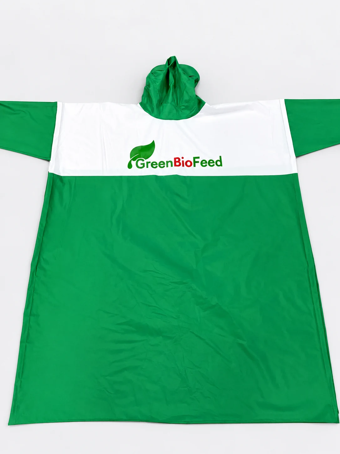 Áo mưa xanh trắng có mũ và phần in GreenBioFeed trong ảnh nguồn