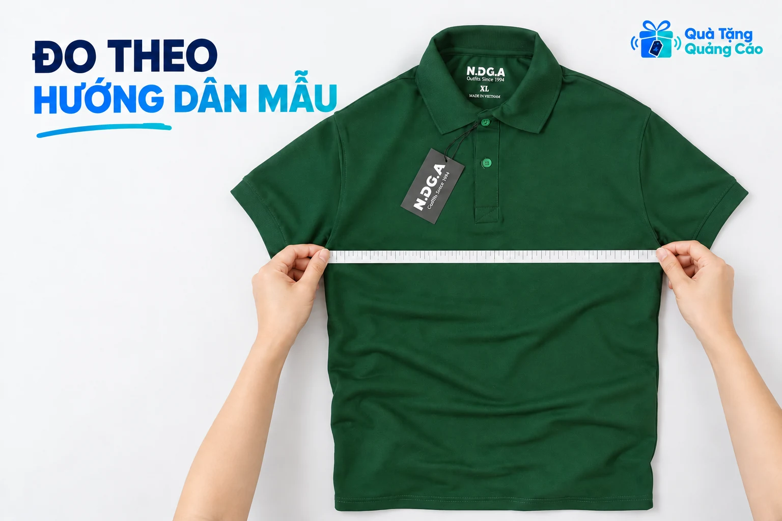 Hai tay đặt thước ngang thân áo polo xanh để minh họa cách đối chiếu kích thước
