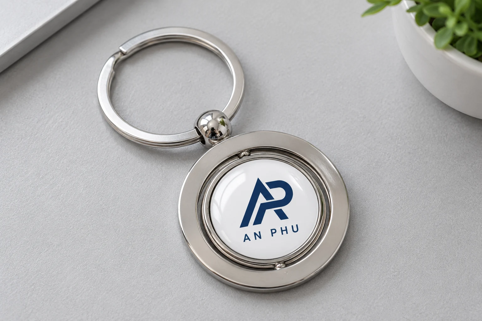 Mô phỏng logo AP AN PHU phủ bóng trên móc khóa tròn Mô phỏng logo AP AN PHU phủ bóng trên móc khóa tròn