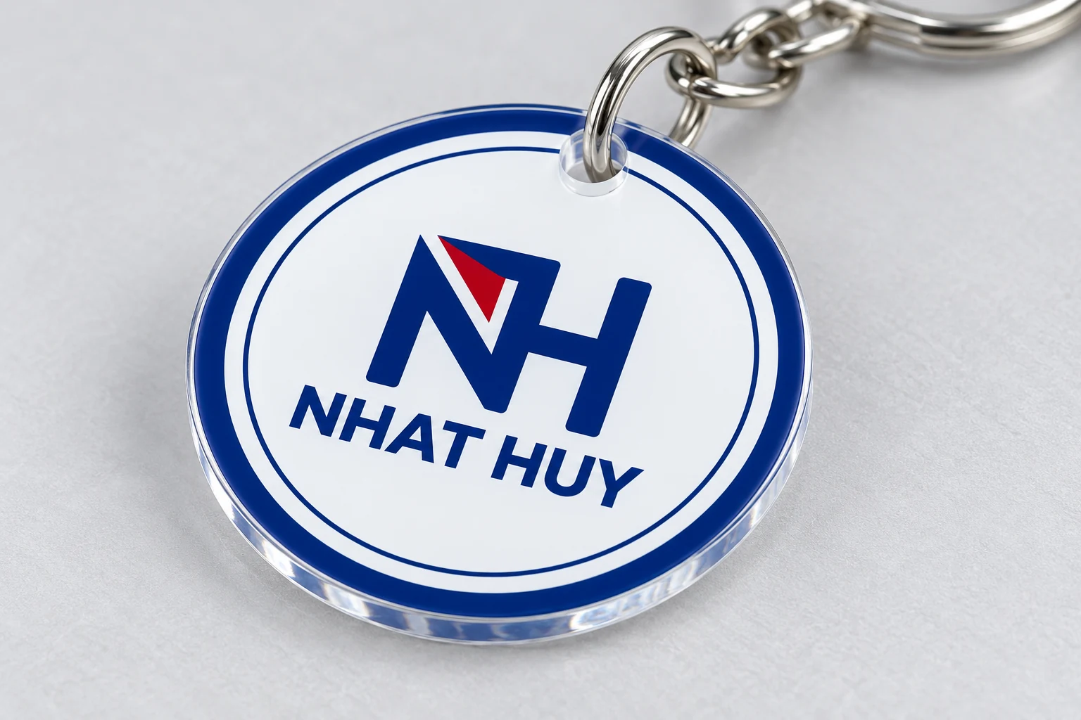 Minh họa mặt in UV NHAT HUY Cận cảnh mặt mica hình tròn có nhận diện NH NHAT HUY và viền trong quanh mép cắt