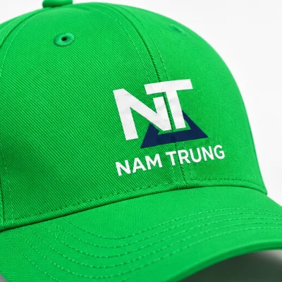 Minh họa cận nhận diện NT NAM TRUNG màu trắng và xanh đậm trên vải mũ xanh lá