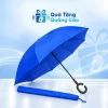 Ô gấp ngược tán xanh và tay cầm chữ C đen cùng bao vải đồng màu trên nền Quà Tặng Quảng Cáo
