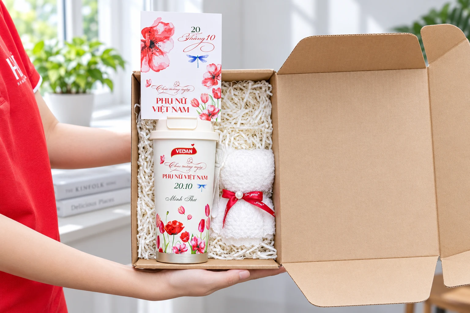 Hộp kraft mở với cốc in hoa, khăn trắng buộc nơ và thiệp
