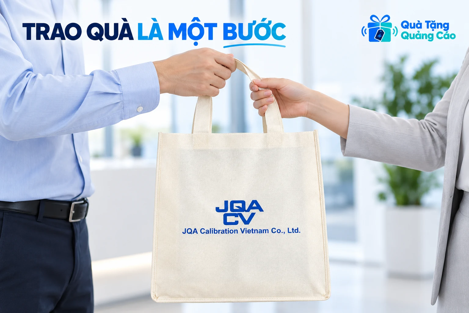 Hai người trao nhận một túi màu kem in JQA tại bàn sự kiện trong cảnh minh họa