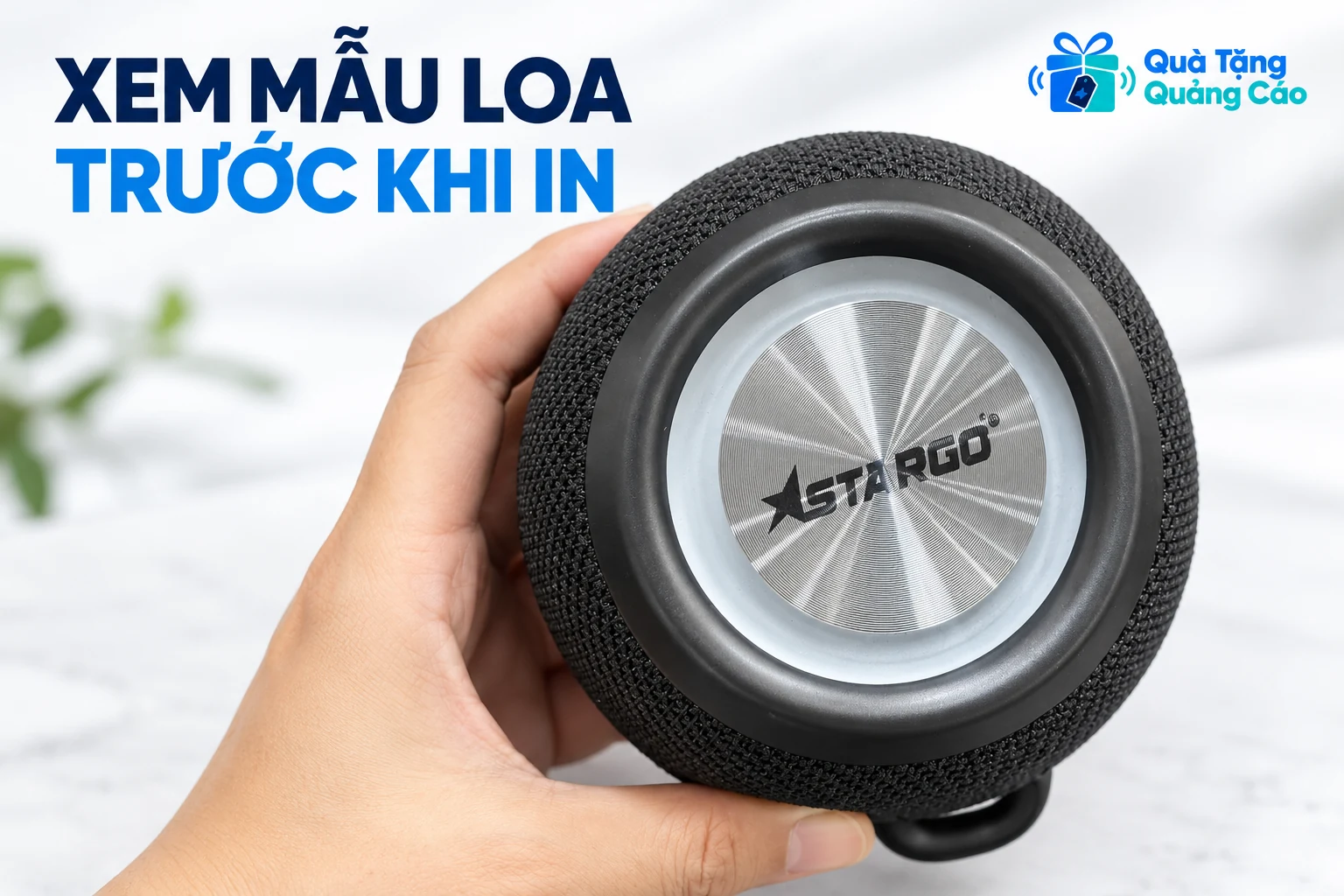 Mẫu loa tròn StarGO có mặt bạc và phần vỏ đen được cầm trên tay