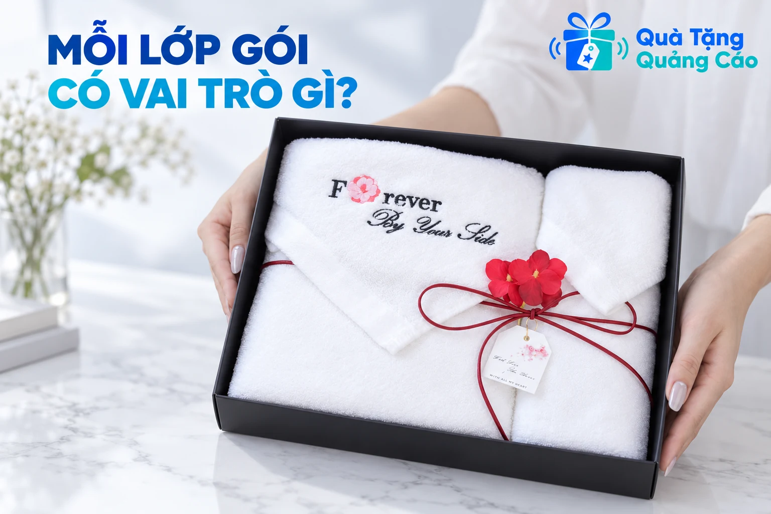 Khăn trắng có chữ thêu, dây đỏ và hoa trong hộp đen theo ảnh nguồn